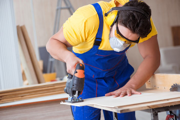 Young repairman carpenter working with a circular saw