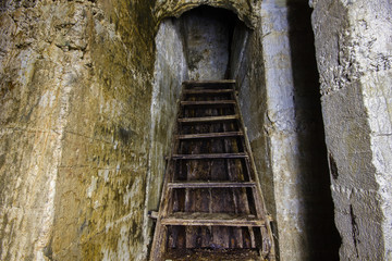 Underground abandoned ore mine shaft tunnel gallery with ladder stairs