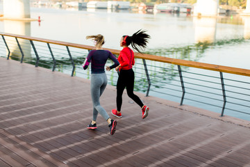 Young women running by the river in the morning