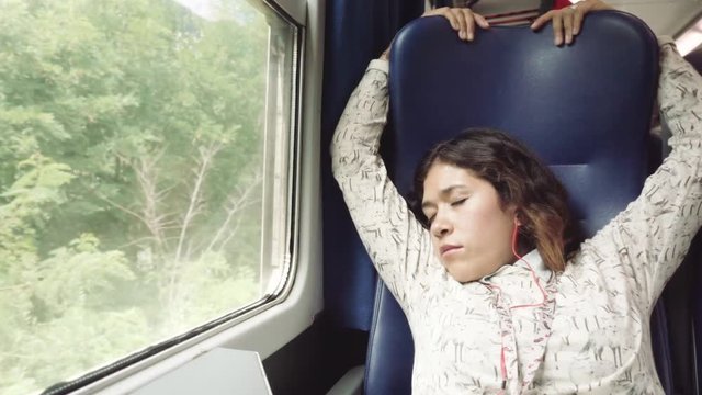 Hispanic woman sleeping in the train peacefully in the corridor seat