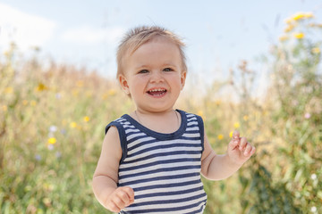 Funny little boy one year old, joyful summer portrait