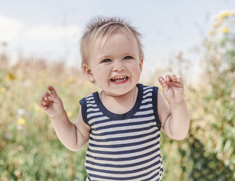 Funny little boy one year old, joyful summer portrait