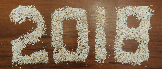 Frame christmas composition of cocoa with marshmallow, cinnamon, anise stars, coffee seeds, fir tree, spoons and ingredients with chopping board on center decorated with made new year tree and lace.
