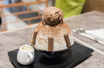 Chocolate bingsu or ice snow flake with Sweetened condensed milk in korea style on wood table, Korean Dessert.