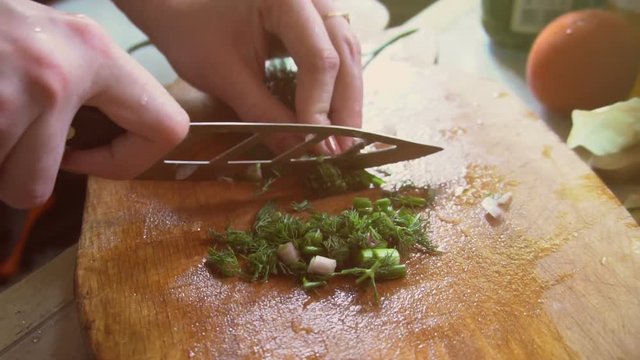 Making Italian pizza, a girl cuts onions
