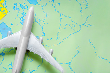 Fototapeta na wymiar miniature of a passenger aircraft flying on a map