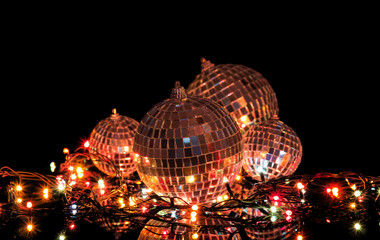 Garland lights and set of mirrored balls on black background