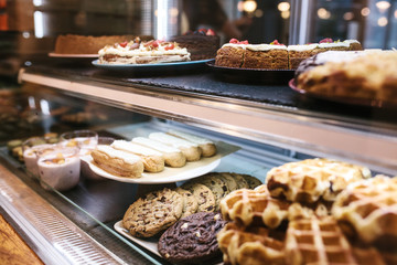 Large selection of cakes and pastries on the counter in a cafe. Sale of delicious sweets.