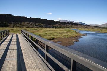 National Park Thingvellir - Almannagjà canyon, Bridge in a typical Icelandic landscape, a wild nature of rocks and shrubs, rivers and lakes.