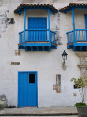 Fototapeta na wymiar Facade of old building with blue balconies and doors