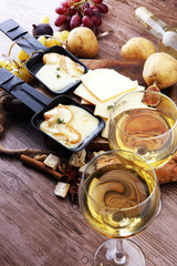Delicious traditional Swiss melted raclette cheese on diced boiled or baked potato served in individual skillets