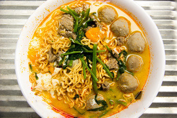 Instant noodles with meat and Meatballs and morning glory in white bowl