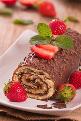 Chocolate roll with hazelnuts and strawberries. 