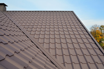 Metal Roof Construction Against Blue Sky. Roofing materials. Metal House roof. Closeup House Construction Building Materials. Roof construction. Coaxial Pipe Heating System House Coaxial Chimney Pipe.