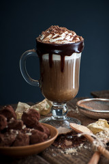 Coffee with cream and sloppy crumbs on an old wooden table..