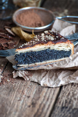 A piece of pie with poppy seeds on an old plaited table..