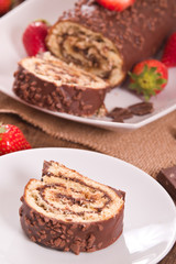 Chocolate roll with hazelnuts and strawberries. 