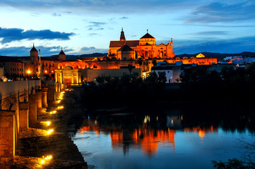 Fototapeta premium Roman bridge and La Mezquita at sunset in Cordoba, Spain