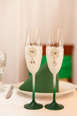 Green wedding decor. Champagne glasses for bride and groom