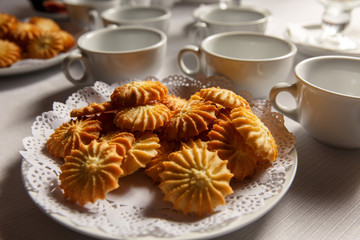 Biscuit, cookie, stacked and sweet near cups for tea or coffee