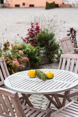 Pumpkin on the wooden table of a street cafe. Decor of Thanksgiving.