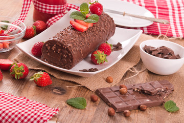 Chocolate roll with hazelnuts and strawberries. 