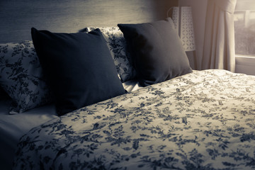 Bed maid-up with clean white pillows and bed sheets in beauty room. Close-up. Lens flair in sunlight.