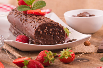 Chocolate roll with hazelnuts and strawberries. 