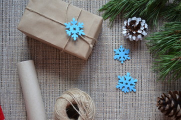 Christmas composition. Christmas gift, knitted blanket, pine cones, fir branches on wooden white background. Flat lay, top view snowflakes christmas treats christmas decorations