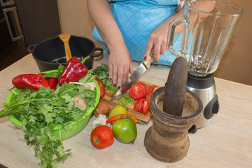 Woman's hands cooking healthy meal in the kitchen, behind fresh vegetables. Cropped image of young girl cutting vegetables for Food