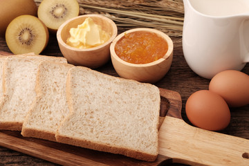 Slice whole wheat bread, butter and orange jam.