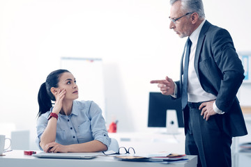 Mad businessman shouting at his young female employee