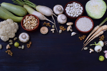 Obraz na płótnie Canvas White vegetables and fruits on a wooden background - currant, cauliflower, champignons, radish, parsley, mushrooms, garlic. Onion, cabbage, mulberry, rice cashew beans Vegetarian food Flat lay