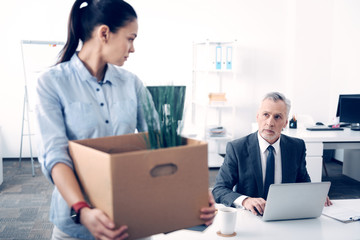 Mature boss looking at his employee leaving office