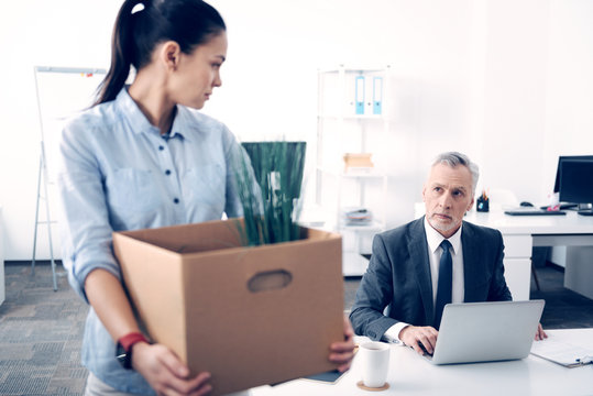 Mature boss looking at his employee leaving office