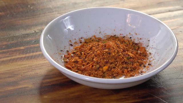 Pouring chipotle garlic powder into a dish