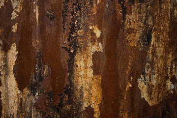 A rusty wall. a piece of metal red old peeling