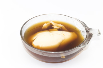 Soft bean curd in hot ginger syrup in transparent bowl