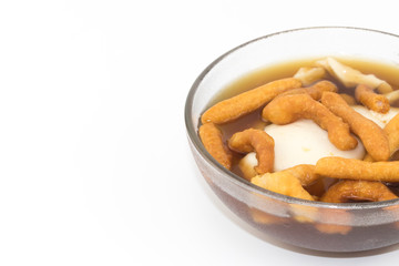 Soft bean curd in hot ginger syrup in transparent bowl