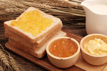Slice whole wheat bread, butter and orange jam.