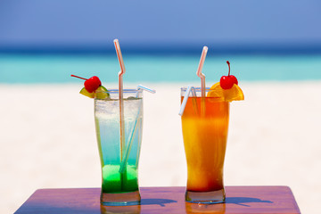 Two colorful cocktails on the beach of an island