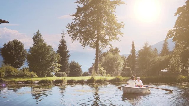 Mother and daughter paddling on boat in a beautiful lake. 4k