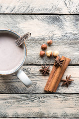 Cocoa drink in rustic cup on wooden table. Top view. Vertical christmas photo. 