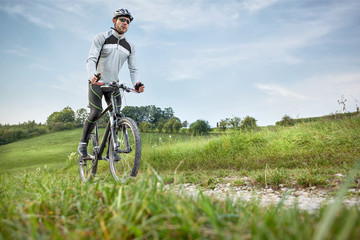 Fototapeta premium Mountainbiker in grüner Landschaft