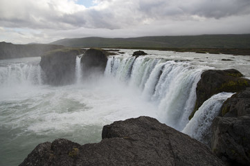 Obraz premium Wonderful view of Gadafoss Falls in a typical Icelandic landscape, a wild nature of rocks and shrubs, rivers and lakes.