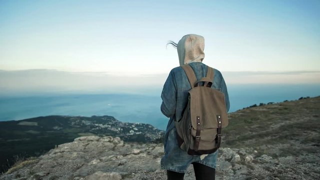 Woman traveler with backpack walking and enjoying view at mountains.