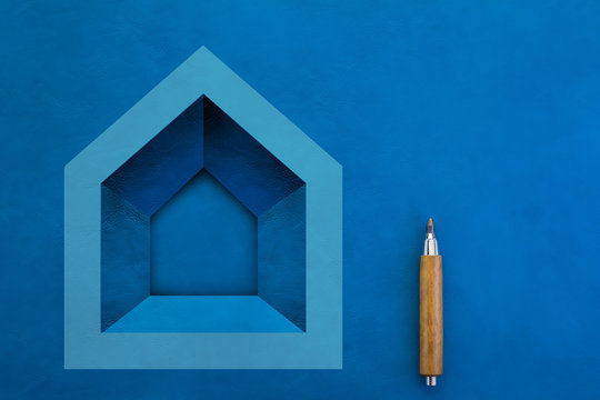 Agent and home buy sell rent concept with blue house papercut shape on blue leather floor with free copyspace and wooden pencil