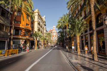 Street view with beautiful luxurious building and palm trees in Valencia city during the sunny day in Spain