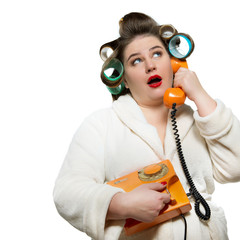 Funny portrait of woman in dressing gown and in curlers with red lips and manicure calling retro...