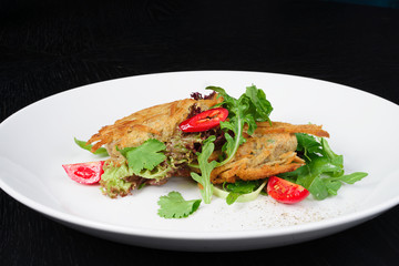 salad with chicken fillets on a white plate black background